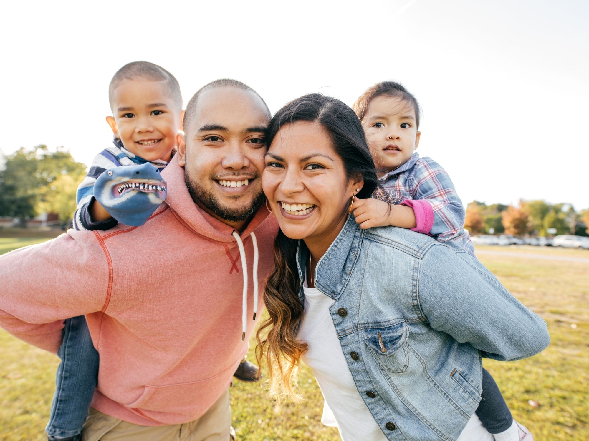 Happy Topeka family with children smiling outdoors - whole family chiropractic wellness care