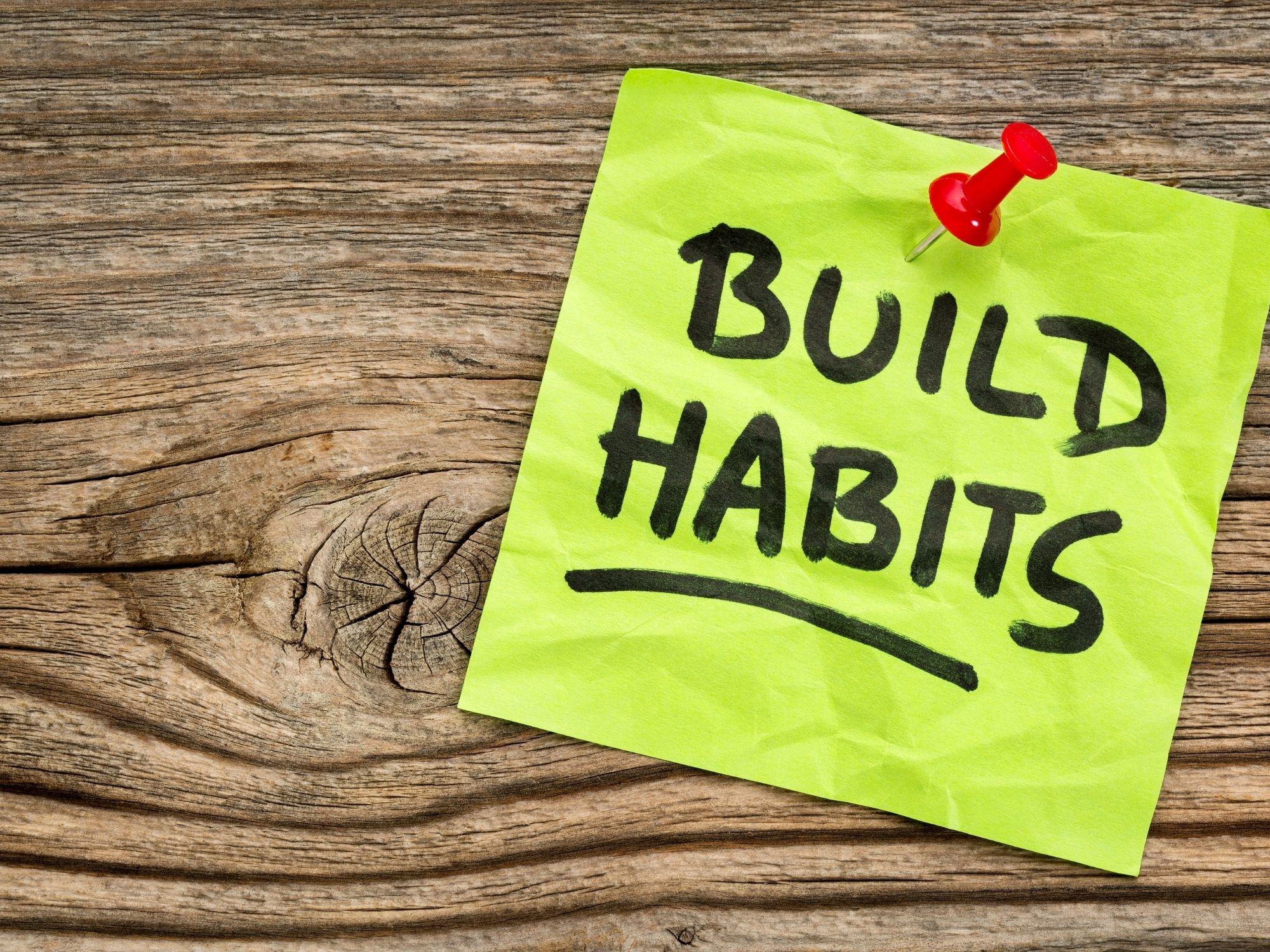 Build habits sticky note on wooden surface - supporting nervous system health through consistent daily choices at Thrive Chiropractic Topeka